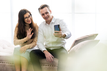 Young happy couple video call to family with laptop computer at home. Online learning and video conference concept