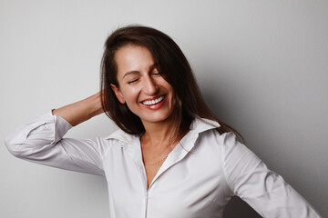 Portrait of young business woman with happy face posing isolated over grey wall background. Space for text.