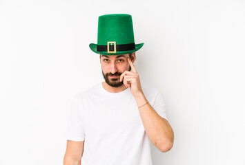 Young caucasian man wearing a saint patricks hat isolated pointing temple with finger, thinking, focused on a task.