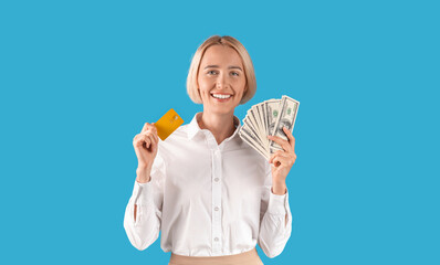 Portrait of happy businesswoman holding money and credit card over blue studio background, panorama