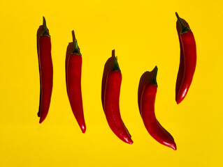 Long red chillies on a yellow sheet.