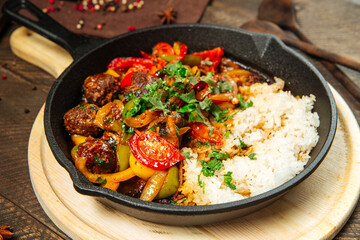 Beef with vegetables and rice in cast iron pan