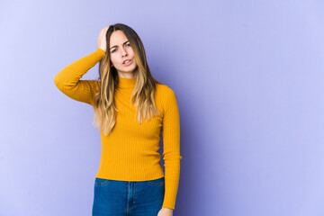 Young caucasian woman isolated on purple background tired and very sleepy keeping hand on head.
