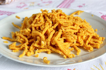 Passatelli crudi su piatto bianco. Cibo tipico della cucina emiliana. Cibo italiano.