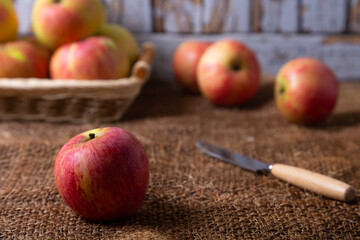 Ripe apples on burlap and in a basket. Rustic style, close-up.