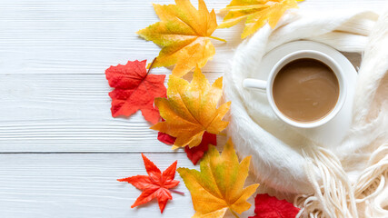 Autumn warm season. Cup of hot coffee with sweater marshmallow on white wood background on sunny day.  warm knitted sweater on season autumn. Lifestyle concept