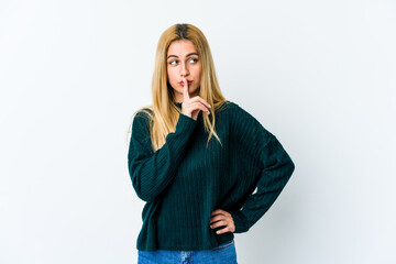 Young blonde woman isolated on white background keeping a secret or asking for silence.