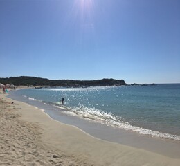 Fototapeta na wymiar Sunny beach in Greece on sunny day with mountain on background clear blue sky