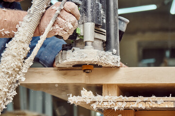 Carpenter with hand electric router machine at work. Milling process of acrylic kitchen countertop