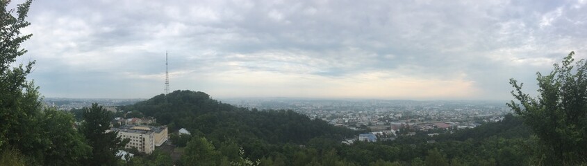 City panorama of Lviv in Ukraine on cloudy summer morning with tower on mountain