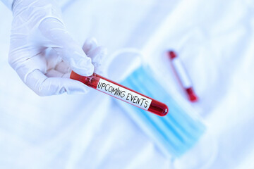 Text sign showing Upcoming Events. Business photo showcasing the approaching planned public or social occasions Extracted blood sample vial ready for medical diagnostic examination
