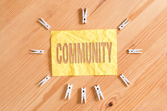 Writing note showing Community. Business concept for group of showing with a common characteristics living together Colored clothespin papers empty reminder wooden floor background office