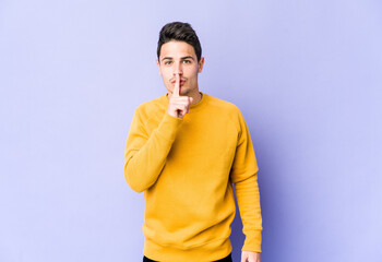 Young caucasian man isolated on purple background keeping a secret or asking for silence.