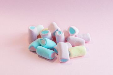 soft, beautiful, appetizing marshmallows lie in a bunch on a pink background. Photo in pastel colors, horizontal photo, close-up, soft focus. Idea - background, postcard, layout, advertisement.