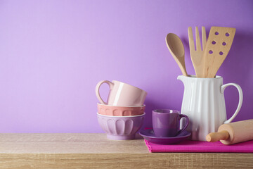 Fototapeta na wymiar Kitchen utensils and dishware on wooden shelf. Kitchen interior purple background