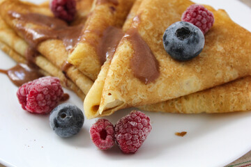 crepes with blueberries. pancakes with fruit. pancakes with berries. pancakes with honey, raspberries, blueberries and chocolate