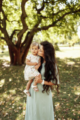 Amazing mother with cute little daughter walking in the forest. 