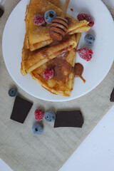 crepes with blueberries. pancakes with fruit. pancakes with berries. pancakes with honey, raspberries, blueberries and chocolate