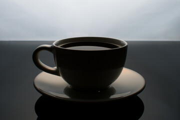 White cup of coffee on a glass table.