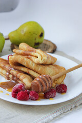 pancakes with fruit. pancakes with berries. pancakes with honey, raspberries and pears