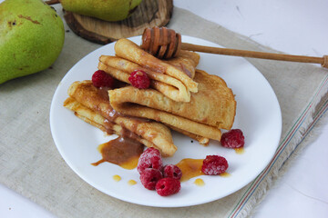 pancakes with fruit. pancakes with berries. pancakes with honey, raspberries and pears