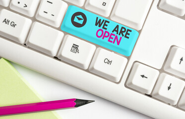 Handwriting text We Are Open. Conceptual photo no enclosing or confining barrier, accessible on all sides Different colored keyboard key with accessories arranged on empty copy space