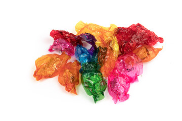 a pile of empty colorful candy wrappers isolated on white