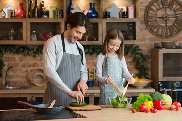 Loving dad teaching his little daughter to cook healthy food