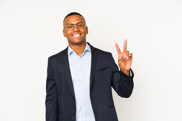 Young business latin man isolated on white background showing victory sign and smiling broadly.