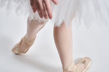 Ballerina in a white tutu dance performed on a light background