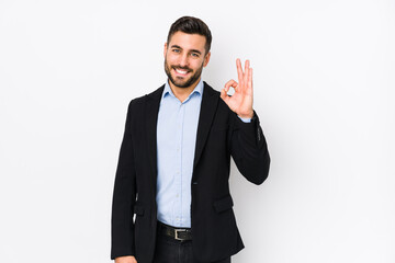 Young caucasian business man against a white background isolated cheerful and confident showing ok...