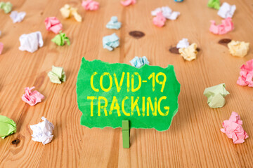 Word writing text Covid 19 Tracking. Business photo showcasing Distinguishing process of the possible infected individuals Colored crumpled papers empty reminder wooden floor background clothespin