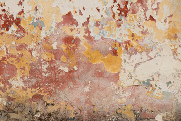 Detail of old flaky chipped cracked wall with scrapes and layers of paint peeling off on neglected house facade
