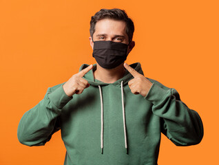 guy in face mask and green hoodie