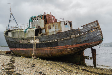Abandoned fishing boat on Caol Beach near Fort William and Ben Nevis