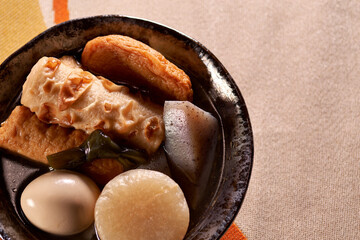 黒い皿に盛りつけられたおでん（煮物）