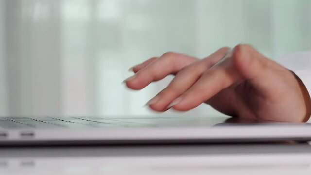 close-up female hand touching touchpad on a laptop computer