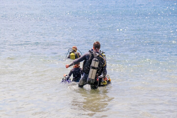 Fototapeta na wymiar divers enter the water on the beach