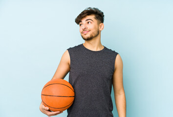 Young arabian man playing basket isolated dreaming of achieving goals and purposes