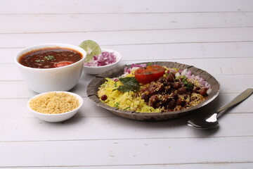 Aloo/Kanda Poha or Tarri Pohe with spicy chana masala/curry. Served in paper plate.