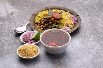 Aloo/Kanda Poha or Tarri Pohe with spicy chana masala/curry. Served in paper plate.