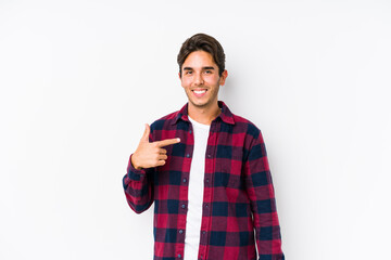 Young caucasian man posing in a pink background isolated person pointing by hand to a shirt copy space, proud and confident