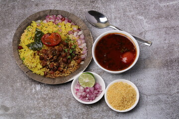 Aloo/Kanda Poha or Tarri Pohe with spicy chana masala/curry. Served in paper plate.