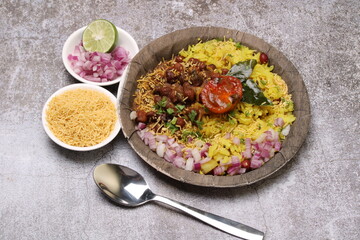 Aloo/Kanda Poha or Tarri Pohe with spicy chana masala/curry. Served in paper plate.