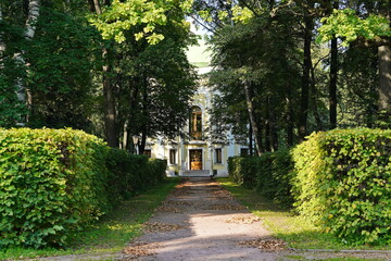 House at the end of an alley on a sunny day in a city park.
