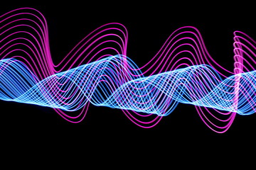 Long exposure photograph of neon pink and blue colour in an abstract swirl, parallel lines pattern against a black background. Light painting photography.