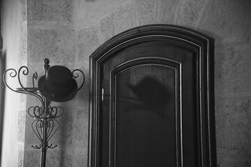 chapeau melon sur porte manteau en noir et blanc