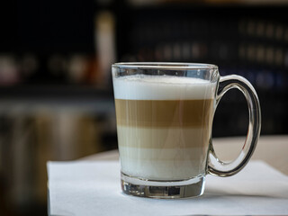 Cafe latte layered coffee in a see through glass coffee cup, hot drink for work time in the morning