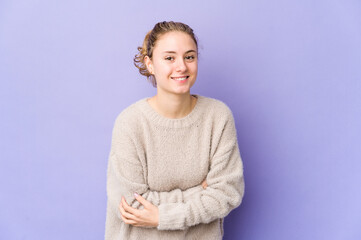 Young caucasian woman on purple background laughing and having fun.