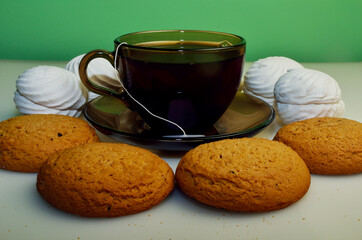 brown cup of tea with sweets